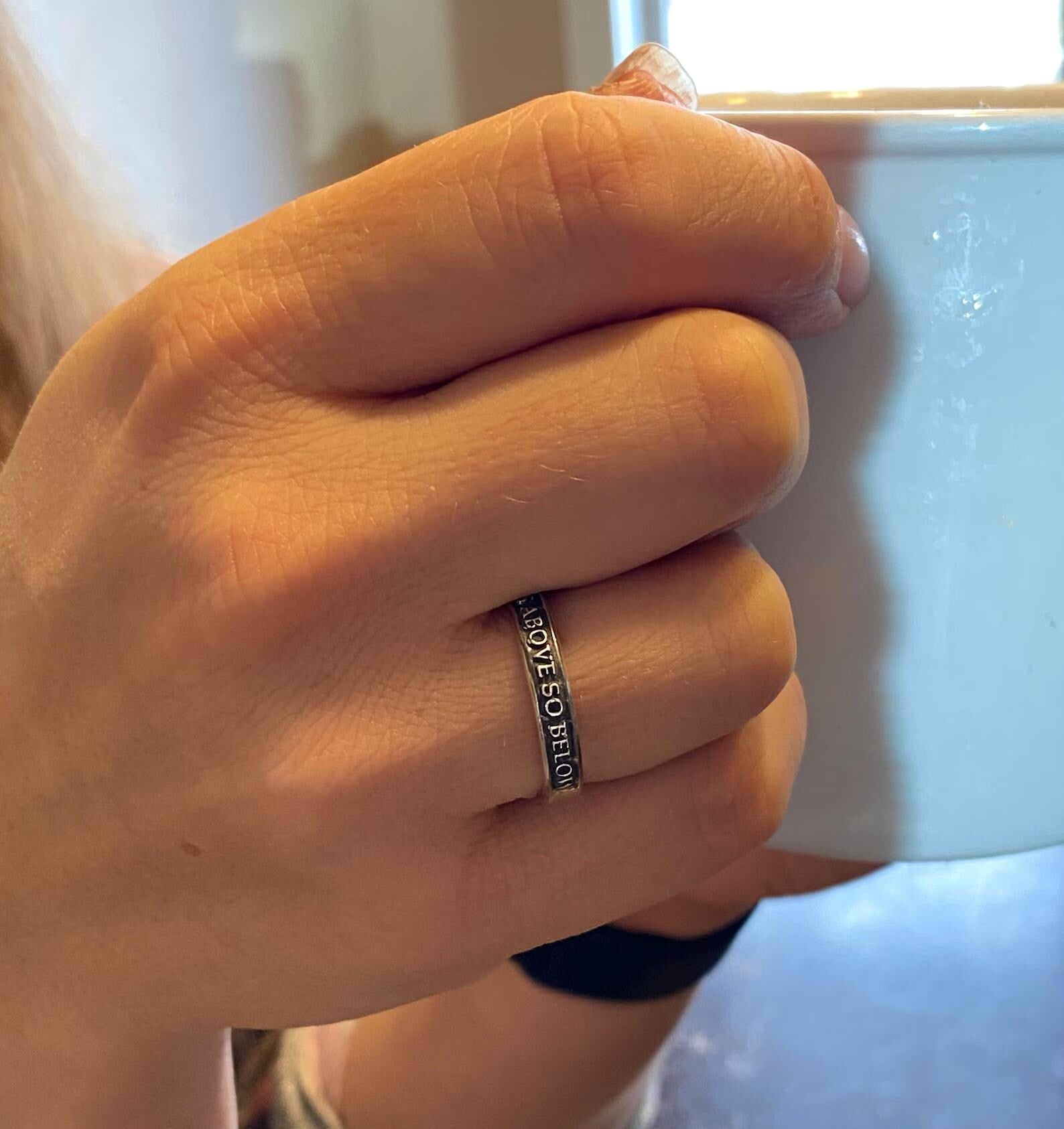 Thin As Above So Below sterling silver ring worn on a finger