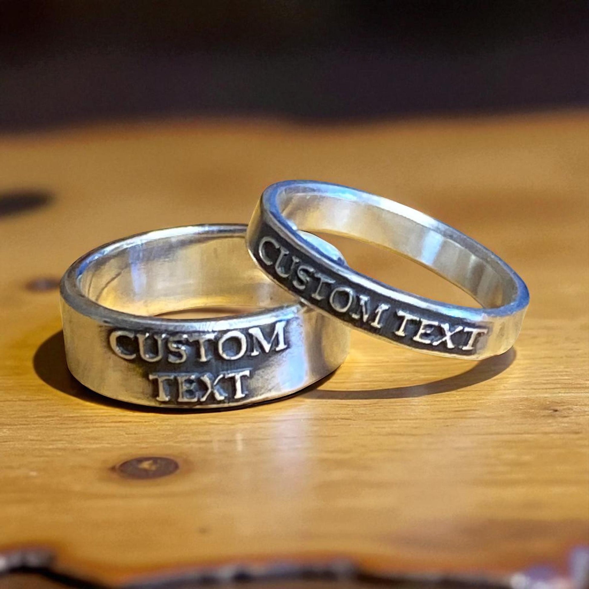 Matching personalized sterling silver rings with raised lettering