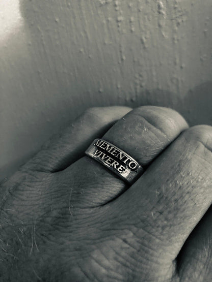Memento Vivere ring showing antiqued raised lettering